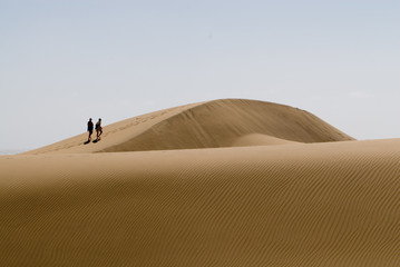 Fototapeta na wymiar two persons walking in the desert
