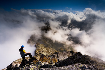 Man on the summit watching beautiful clouds