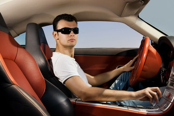 Handsome young man driving modern sport car