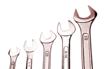 Five spanners over white background