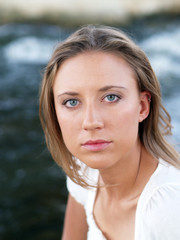 Young blond woman portrait outdoors with water