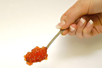 Hand holding the spoon with red caviar © Ilya Postnikov