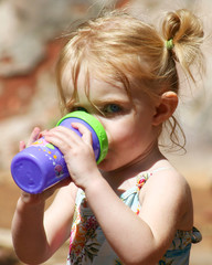 This two-year-old gazes skeptically over her sippy cup