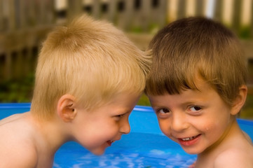 Two brothers enjoying summer in their paddling pool.