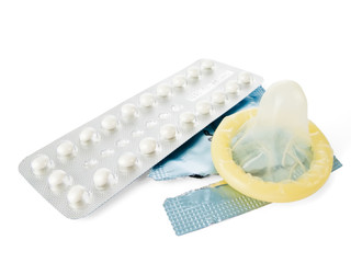 Birth Control Pills and a Condom isolated on white.