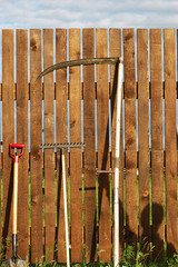 garden tool set over wood backyard fence
