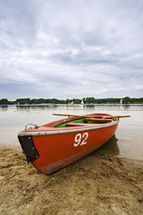 rotes ruderboot am strand eines sees
