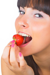 Brunette girl eating a strawberry