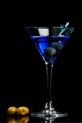 Blue martini with olives on black background