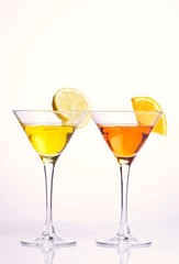 Two colorful cocktails with fruits on white background