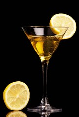 Yellow cocktail with lemon on black background