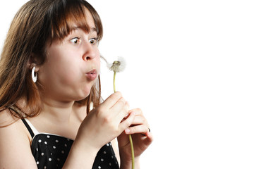 young teen blowing dandelion