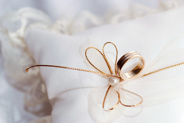 Gold wedding ring on a pillow