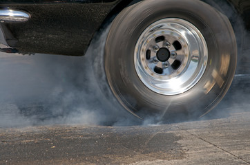 Smoke from the tires of a black racer