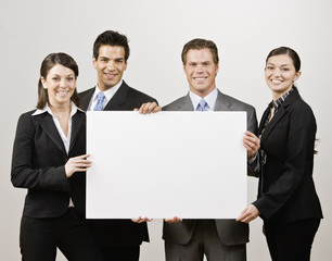 Business people holding blank poster board