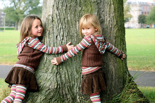Sisters hugging a tree