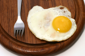 served fried egg on wooden plate