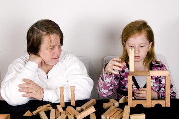 grandmother is watching while grandchild is playing