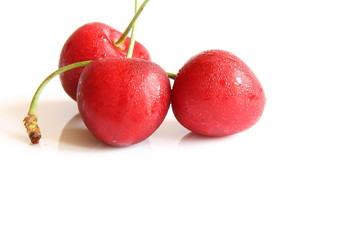 Three ripe cherries on white background