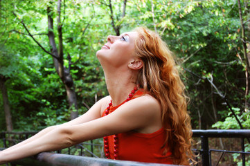 Redhead girl enjoying nature in forest