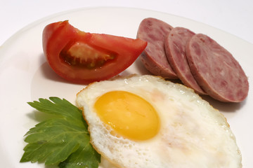 sausage slices with fried egg tomato and celery