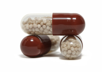 Close-up of three pills on white