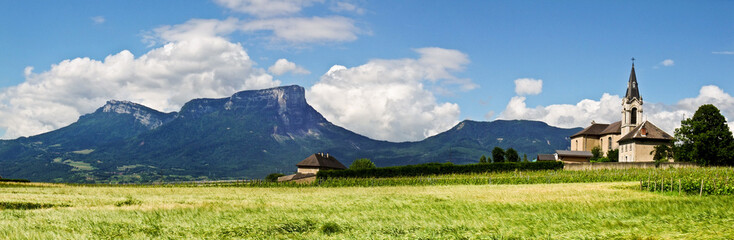Eglise, champ de blé et montagne en Savoie