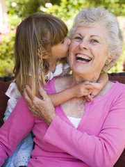 Grandmother getting a kiss from granddaughter