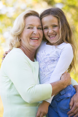 Grandmother and granddaughter outdoors and smiling