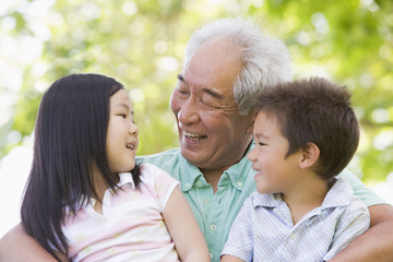 Grandfather laughing with grandchildren - obrazy, fototapety, plakaty