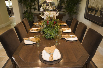 Dining table with luxury tableware and furniture.