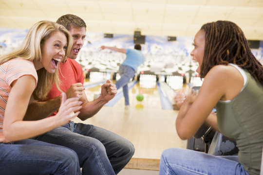 Young adults cheering in a bowling alley