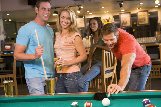 Young adults playing pool in a bar