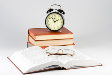 Alarm clock, book and eyeglasses