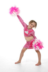 Cute girl in pink cheerleader outfit holding pompoms 