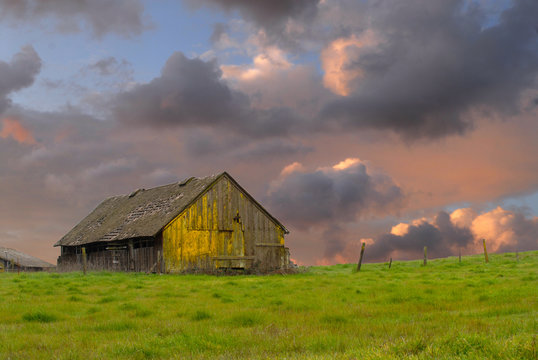 Old weathered abandoned barn in a field