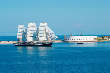 Fototapeta na wymiar Sailing ship entering to the bay.