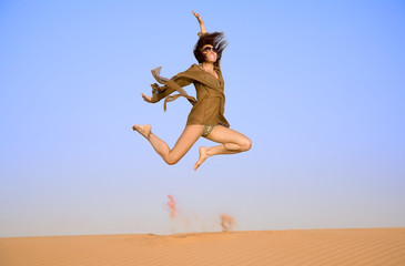 Jumping girl on the sand  