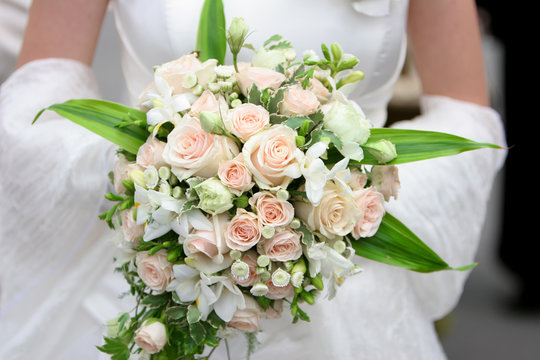 An image of a bride holding her bouquet of roses