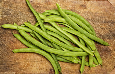Green beans on wooden table, studio shot.