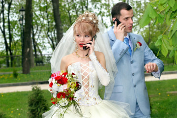 Bride and groom talk by phones