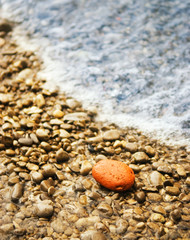 Ocean wave washes stone beach