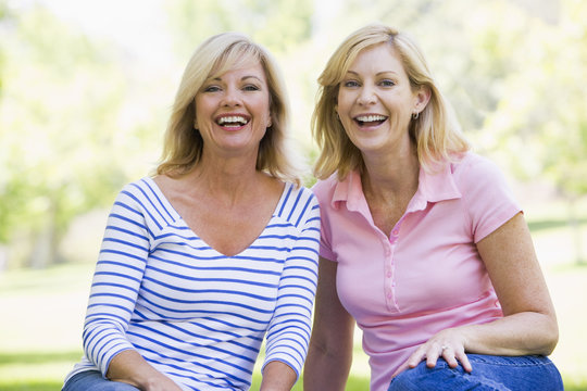 Two women sitting outdoors smiling