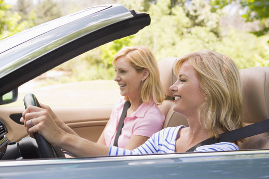 Two women in convertible car smiling