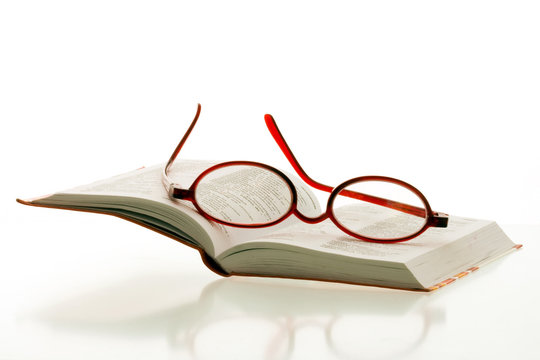 red reading glasses on the pages of an open book