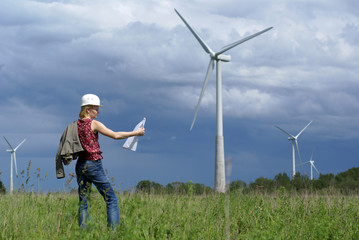 Woman engineer or architect with white safety hat and wind turbi