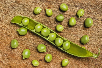 Fresh green peas on wooden background, studio shot.