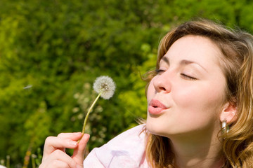 happy girl blowing on the dandelion