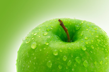 Top of a crisp green apple with water droplets