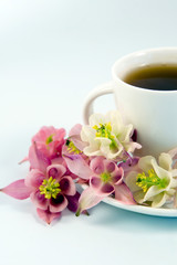 White teacup with tea and flowers